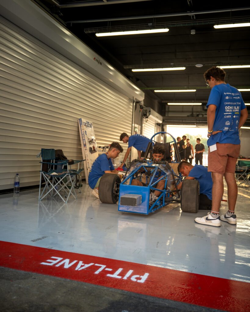 Equipo trabajando en el monoplaza junto a la línea del pit lane
