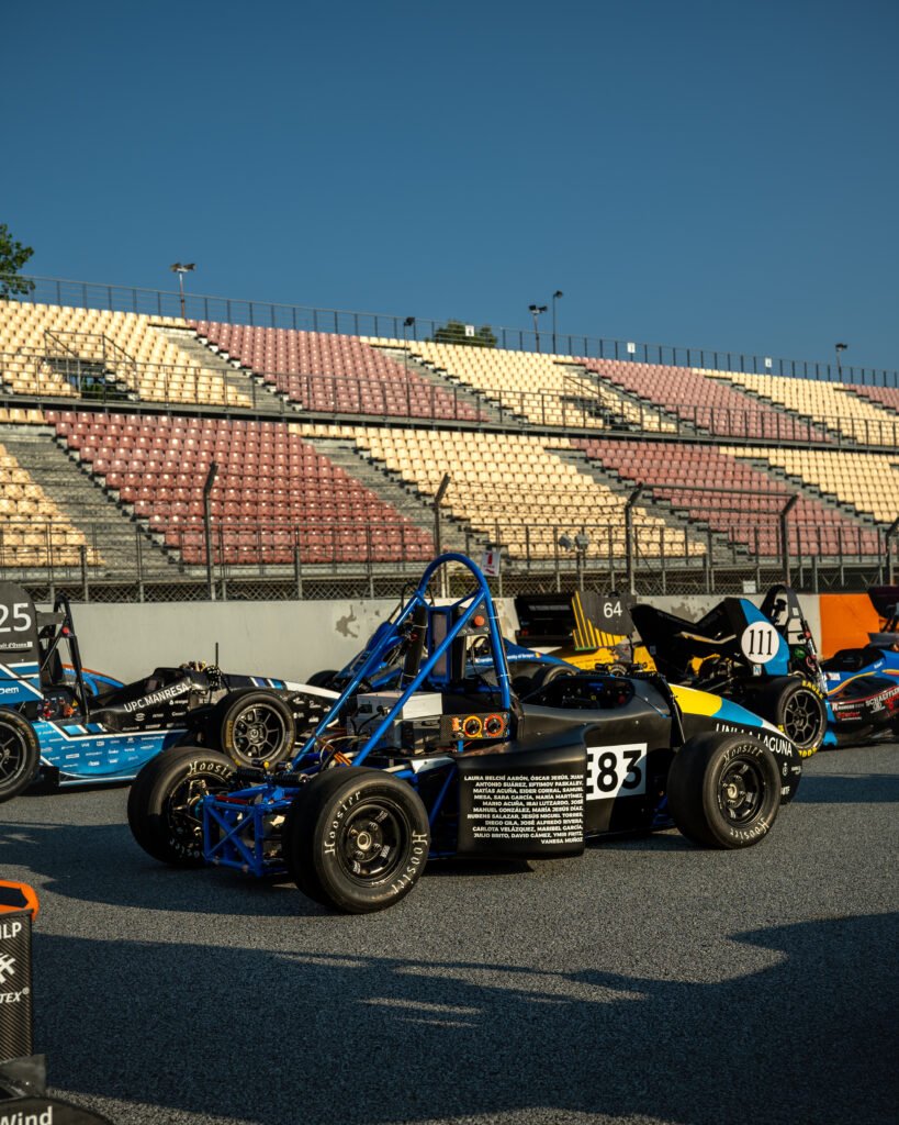 Monoplaza número 83 en el paddock con las gradas al fondo