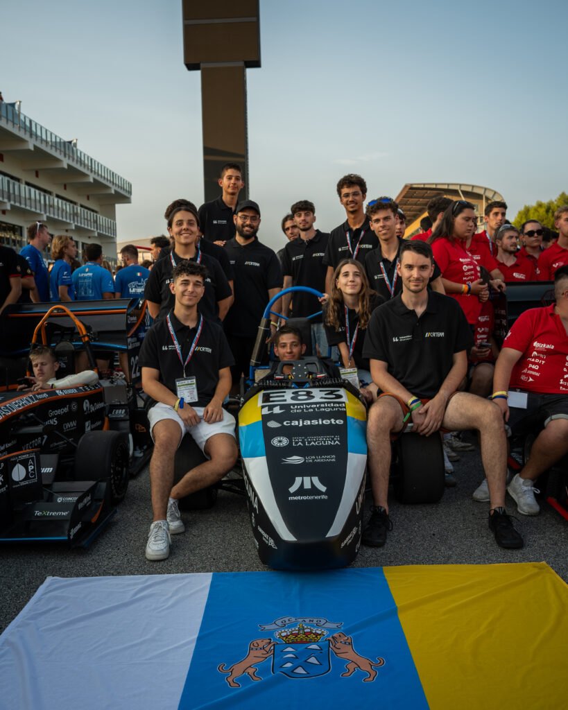 Foto de grupo de Canarias Racing Team con el monoplaza y la bandera canaria