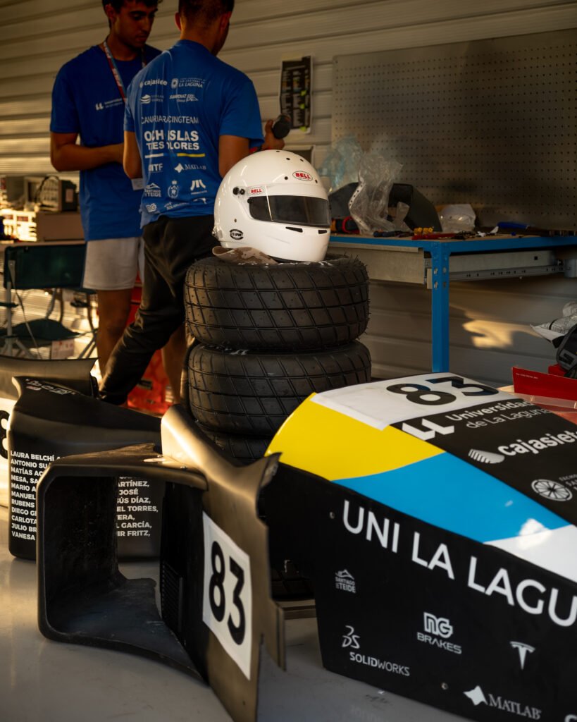 Casco blanco sobre los neumáticos junto al carenado número 83