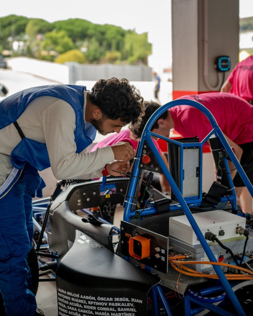 Miembro del equipo revisando el cableado del monoplaza en el box