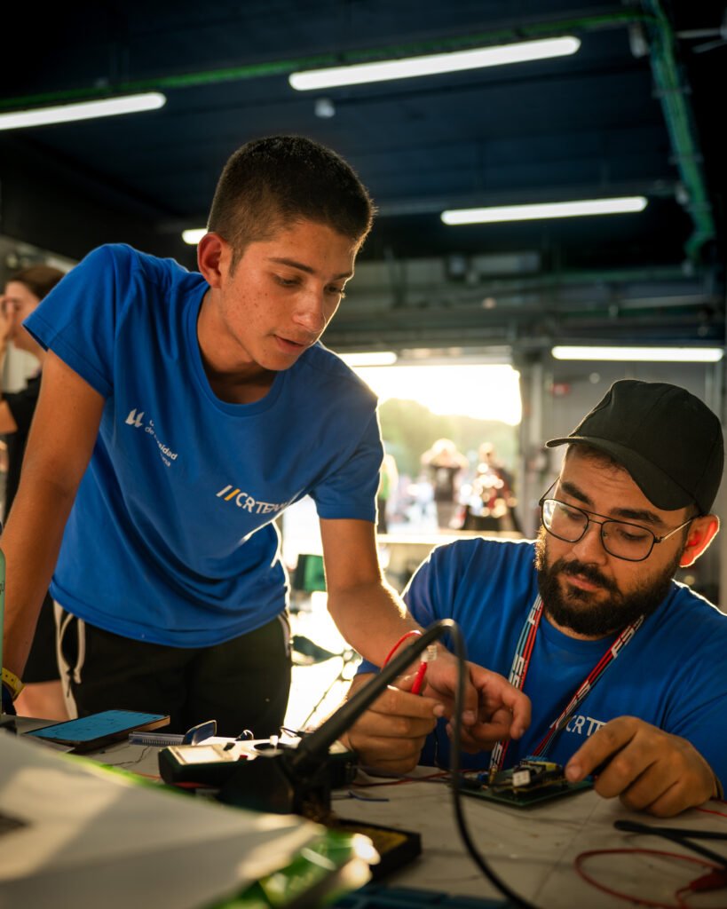 Dos miembros del equipo trabajando en la electrónica en el box